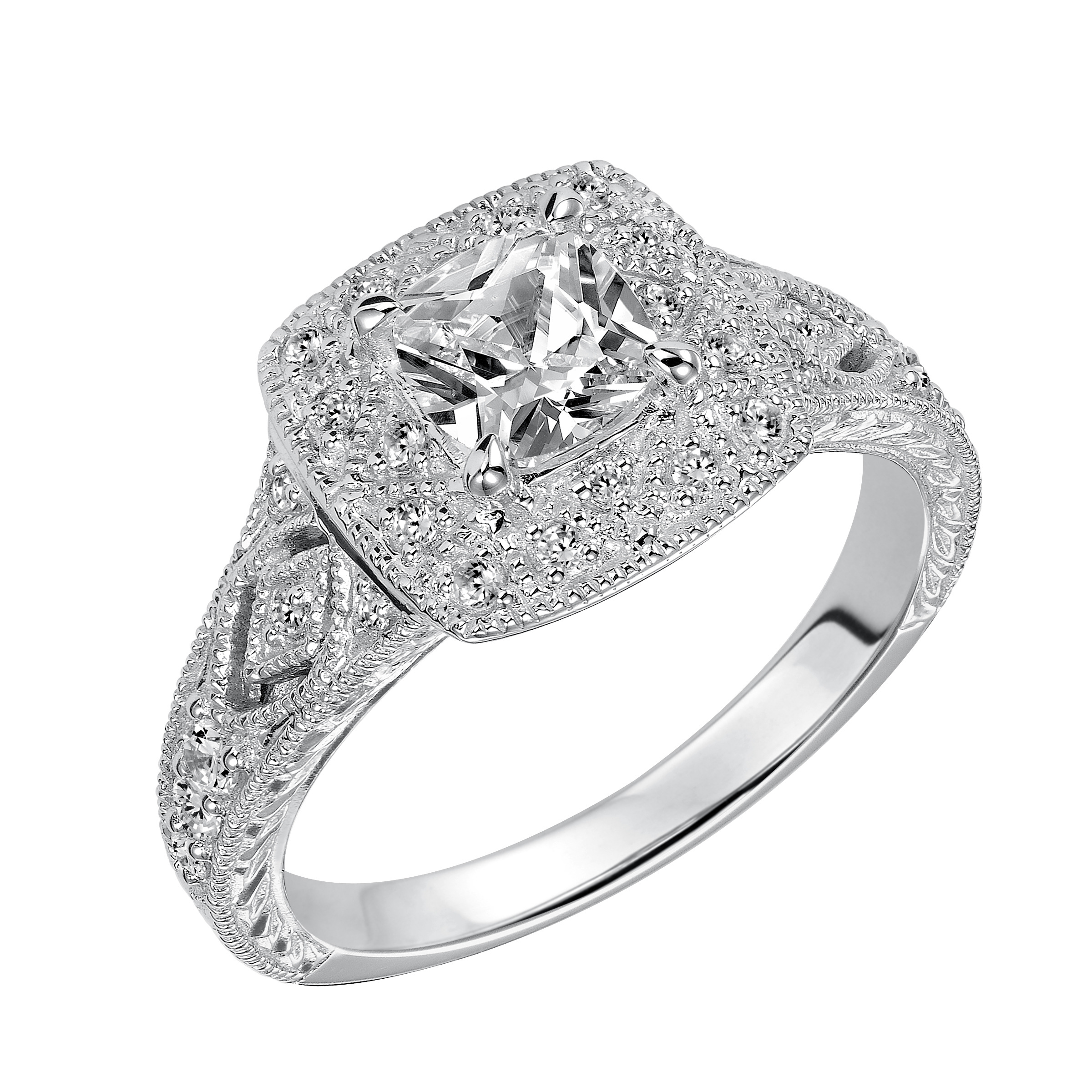 This cushion cut diamond engagement ring features a beautifully dramatic diamond prong set halo and band enhanced with engraving and milgrain