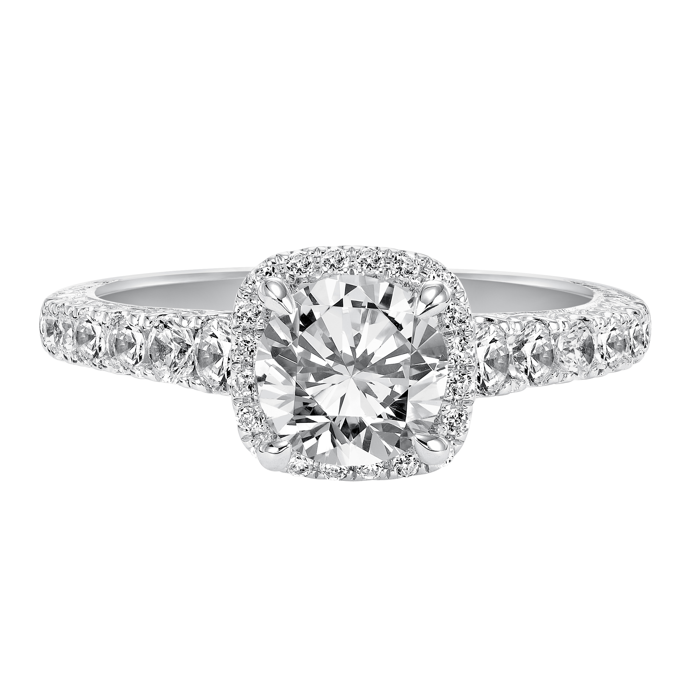 This alluring round diamond engagement ring gleams with a prong set diamond halo and prong set diamond band enhanced with delicate engraving